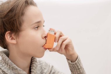 Çocuk, genç bronkodilatuar solunum uygular, ilaç spreyini içine çeker, astımı kontrol altına alır.