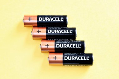 Sarı zemin üzerinde Duracell marka 4 alkali batarya, yakın plan piller