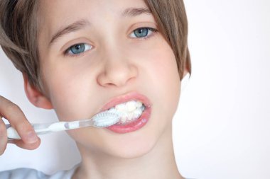 Oğlan dişlerini diş fırçası, yakın plan portre, günlük hijyen ve diş sağlığı kavramları ile fırçalar.