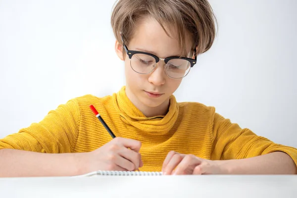 Pojke gör läxor på en vit bakgrund — Stockfoto