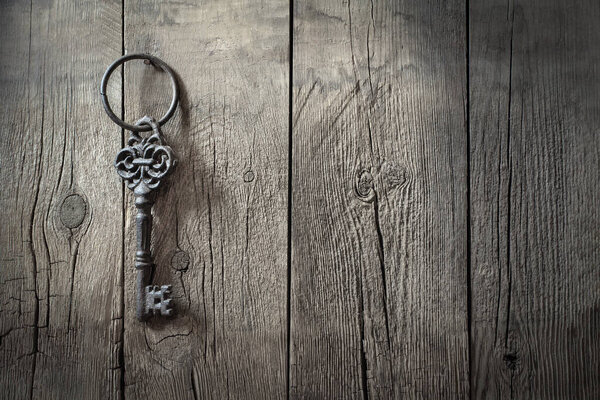 старое железо большой ретро ключ висит на гвоздь против деревенской деревянной стены, концепция секрета, наследство, возможность
