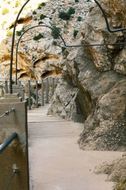 Kahverengi kızıl dağlar patikanın yakınındaki sarp kayalıkları, İspanya 'daki dik uçurumları, Ardales Caminito del Rey' i kaplar. El Chorro 'daki uzun kırmızı kayalıklar.