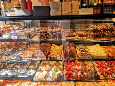 Amsterdam, Hollanda, Temmuz 2019: Bir çok lezzetli tatlı, kek, bisküvi, meyveli kurabiye ve marihuana ile tatlılar içeren şekerci dükkânı vitrini