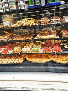 Amsterdam, Hollanda, Temmuz 2019: Bir çok lezzetli tatlı, kek, bisküvi, meyveli kurabiye ve marihuana ile tatlılar içeren şekerci dükkânı vitrini