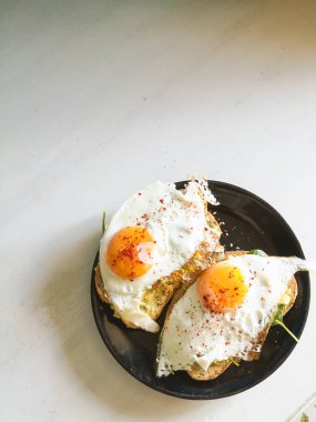 Siyah tabakta yumurta ve ıspanaklı buğday sandviçi, sağlıklı besleyici kahvaltı, diyet yemek. 