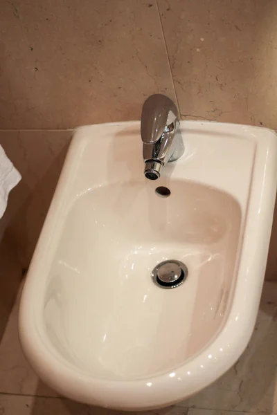 Otelin Banyosunda Duvarında Pembe Mermer Fayanslar Olan Beyaz Taharet Oturağı — Stok fotoğraf