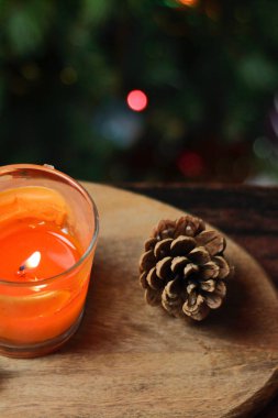 Ahşap bir standın üzerinde Noel portakallı bir mum, bir tutam tarçın, ökseotu ve oyuncaklarla süslenmiş bir Noel ağacı. Noel Yeni Yıl Akşam Havası, Tebrik Kartı