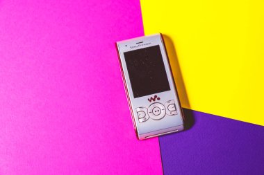 Saint-Petersburg, Rusya - 03 Mart 2020: Eski bir retro, 2000 'lerden kalma pembe menekşe arka planda siyah vintage cep telefonu clamshell sony ericsson kullanıldı. İllüstrasyon Editörü