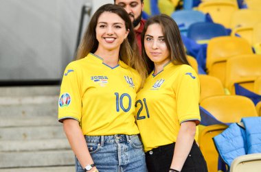 KYIV, UKRAINE - October 14, 2019: Ukrainian girls in the uniform of the national team of Ukraine pose for the camera at the stadium supporting the team, Ukraine