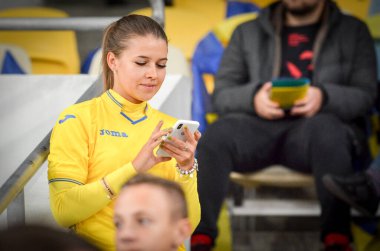 KYIV, UKRAINE - October 14, 2019: Ukrainian girls in the uniform of the national team of Ukraine pose for the camera at the stadium supporting the team, Ukraine