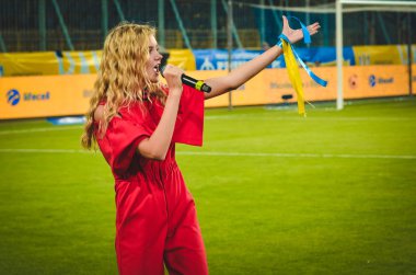DNIPRO, UKRAINE - September 10, 2019: Singer and beautiful girl emotionally performs at the stadium during the friendly match between national team Ukraine against Nigeria, Ukraine