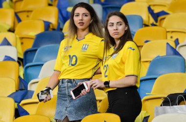 KYIV, UKRAINE - October 14, 2019: Ukrainian girls in the uniform of the national team of Ukraine pose for the camera at the stadium supporting the team, Ukraine