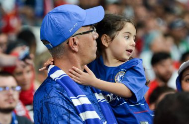 Istanbul, Turkey - August 14, 2019: Father with daughter in his arms in Chelsea T-shirts support the team during the UEFA Super Cup Finals match between Liverpool and Chelsea, Turkey
