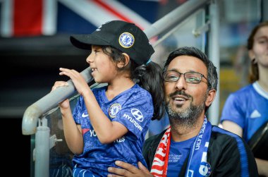 Istanbul, Turkey - August 14, 2019: Father with daughter in his arms in Chelsea T-shirts support the team during the UEFA Super Cup Finals match between Liverpool and Chelsea, Turkey