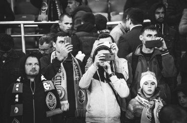 KHARKIV, UKRAINE - September 18, 2019: Football fans on the stadium support the team with phone during the UEFA Champions League match,  Ukraine
