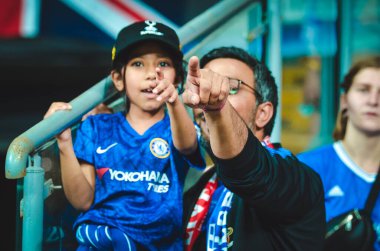 Istanbul, Turkey - August 14, 2019: Father with daughter in his arms in Chelsea T-shirts support the team during the UEFA Super Cup Finals match between Liverpool and Chelsea, Turkey