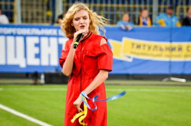 DNIPRO, UKRAINE - September 10, 2019: Singer and beautiful girl emotionally performs at the stadium during the friendly match between national team Ukraine against Nigeria, Ukraine