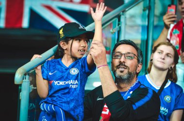 Istanbul, Turkey - August 14, 2019: Father with daughter in his arms in Chelsea T-shirts support the team during the UEFA Super Cup Finals match between Liverpool and Chelsea, Turkey