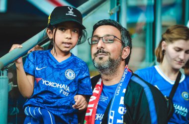 Istanbul, Turkey - August 14, 2019: Father with daughter in his arms in Chelsea T-shirts support the team during the UEFA Super Cup Finals match between Liverpool and Chelsea, Turkey