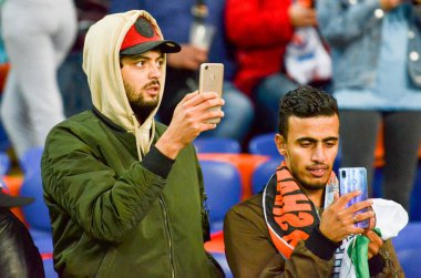 KHARKIV, UKRAINE - September 18, 2019: Football fans on the stadium support the team with phone during the UEFA Champions League match,  Ukraine