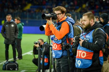 KHARKIV, UKRAINE - September 18, 2019: Photographers make a report with cameras and lenses during the UEFA Champions League match, Ukraine