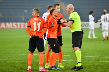 Kharkiv, Ukrayna - 20 Şubat 2020: Shakhtar futbolcuları Uefa Avrupa Ligi maçında hakem Bobby Maddenle tartıştı Shakhtar Donetsk - Sl Benfica, Ukrayna