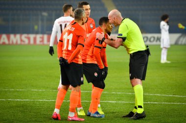 Kharkiv, Ukrayna - 20 Şubat 2020: Shakhtar futbolcuları Uefa Avrupa Ligi maçında hakem Bobby Maddenle tartıştı Shakhtar Donetsk - Sl Benfica, Ukrayna