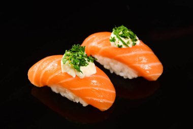 Siyah arka plan üzerine somon Nigiri suşi