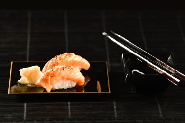 Siyah arka plan üzerine somon Nigiri suşi