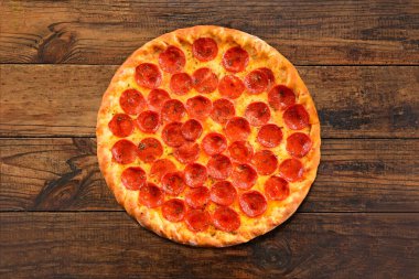 Ahşap arka planda pepperoni pizza.