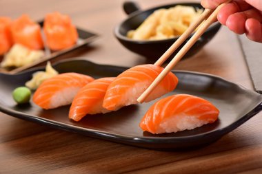 Nigiri suşi tutan Chopstiks