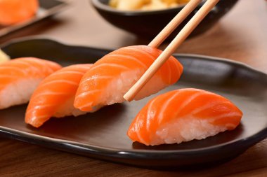 Nigiri suşi tutan Chopstiks