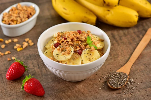 Bananas and Granola bowl on wooden background