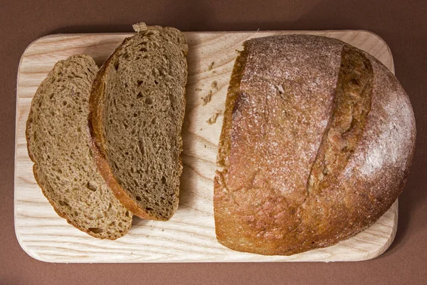 Bir ahşap tahta üzerinde siyah ekmek dilimlenmiş — Stok fotoğraf