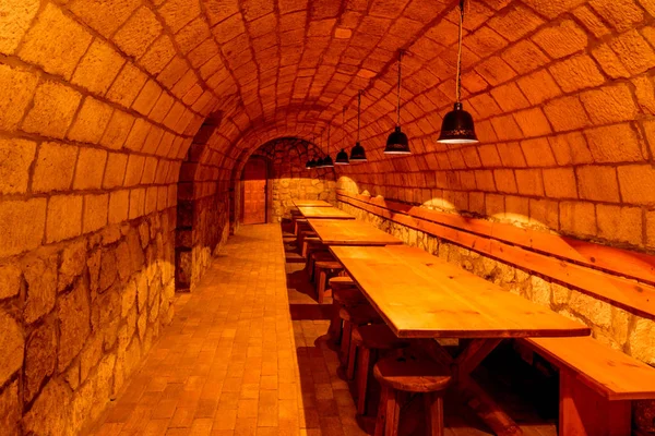 酒窖里舒适的地下酒吧里的长木桌和长椅 — 图库照片