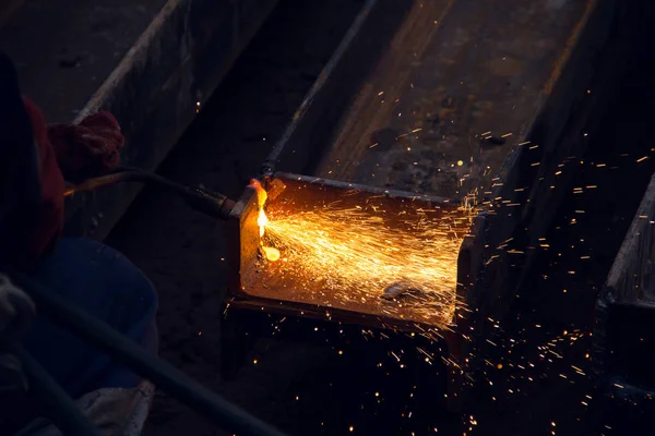 Cutting a steel beam with a gas torch. Industrial metal cutting.