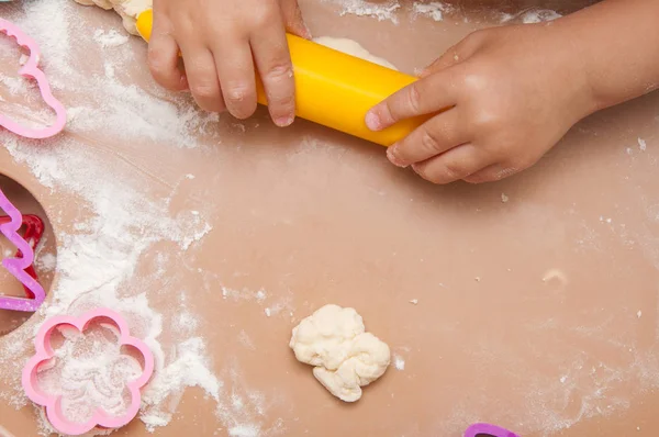 The child makes homemade pastry from the dough. Cooking from home dough.