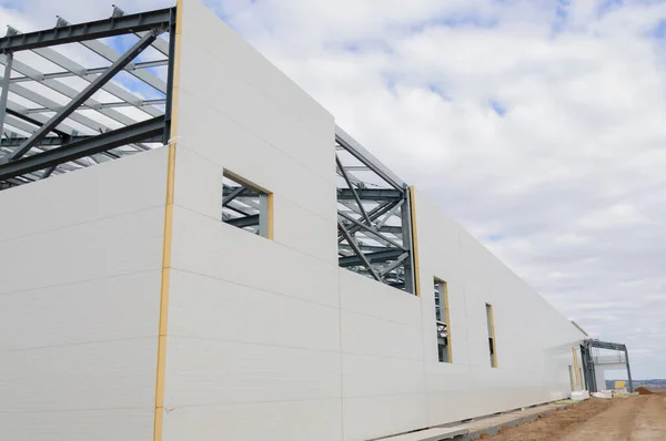 Metal frame of the building with a sandwich panel of insulation on the wall. The use of modern building materials