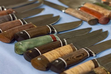 Bir dizi avcı bıçağında birkaç tane. Seçici odaklanma. Yukarıdan ön görünüm.