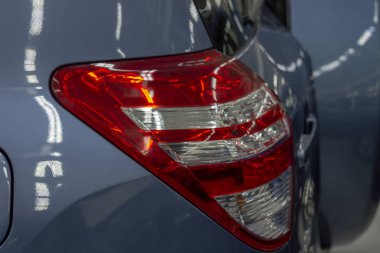 Mavi cipin arka lambası ve yedek lastiğin kapağı. Lambaların parıltısı. Kapatın. Yan görünüm.