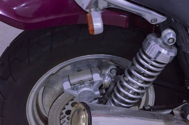 Arka tekerlek, şok emici ve motorun egzoz borusunun bir parçası. Kapatın. Üst taraf görünümü.