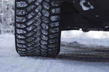 Wheel of car is coated in winter tires in snow. View from the front.