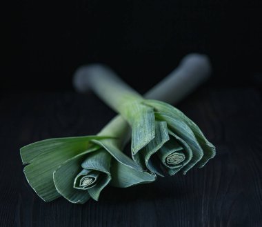 Koyu arkaplanda pırasa ve doğal ışık