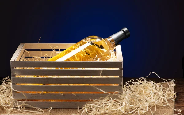 Gift bottle of white wine shot close-up on a blue background — Stock Photo, Image
