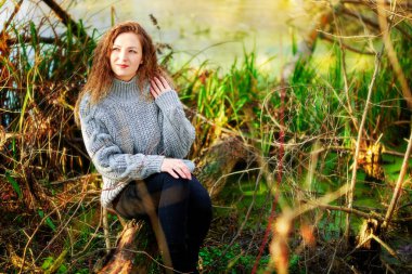 Kıvırcık saçlı kız sonbaharda bulanık bir arkaplanda nane şekeri