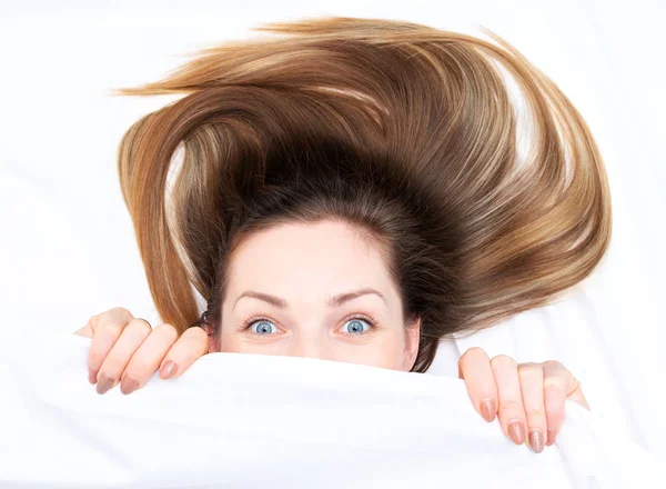 Erstaunliche Mädchen mit offenen Augen, die unter den Deckeln hervorschauen — Stockfoto