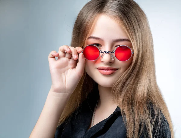 Beautiful young girl in sunglasses with mirror glasses in the studio — Stock Photo, Image