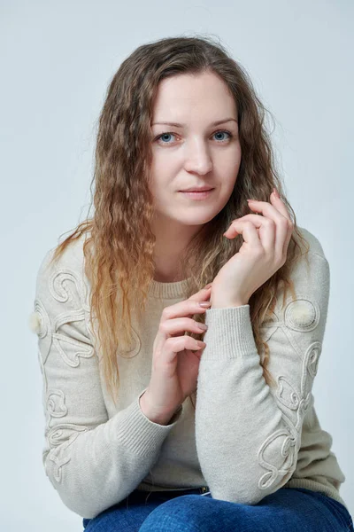 Ung kvinna poserar framför kameran med lockigt hår — Stockfoto
