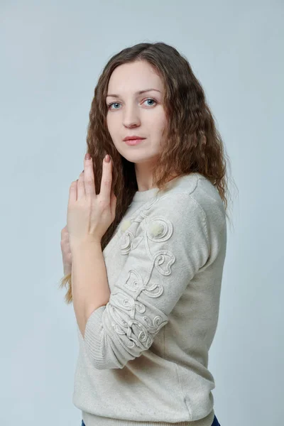 Ung kvinna poserar framför kameran med lockigt hår — Stockfoto