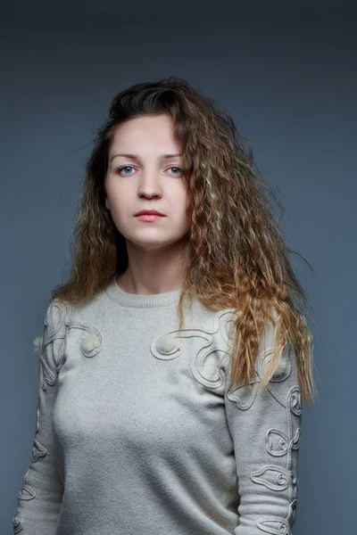 Jovem posando na frente da câmera com cabelo encaracolado — Fotografia de Stock